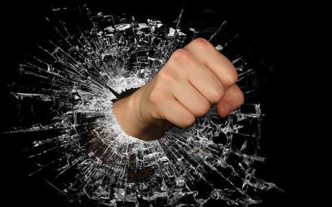 A fist punching through a glass hole