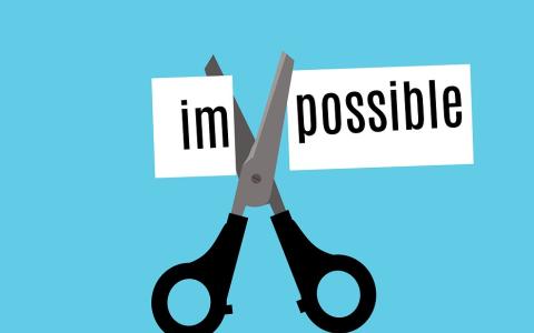 a scissors cutting the word impossible into two sections with "im" and "possible"