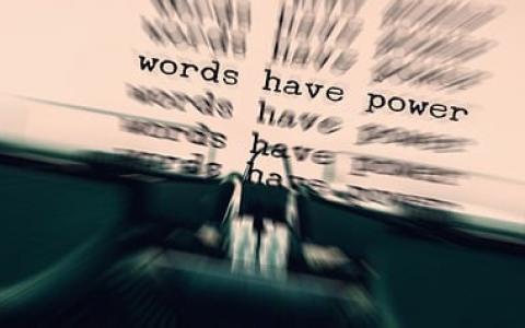 "words have power" having been typed by a typewriter many times on an 8 1/2" by 11" white paper