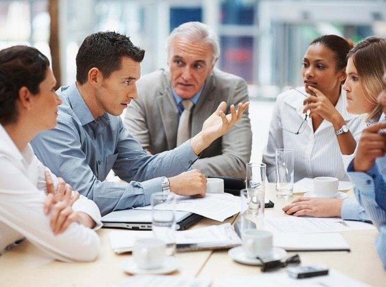 Five people negotiating in a meeting