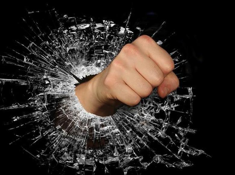 A fist punching through a glass hole