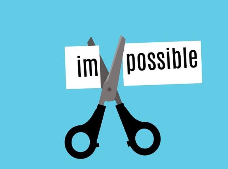 A scissors cutting the word impossible to im and possible