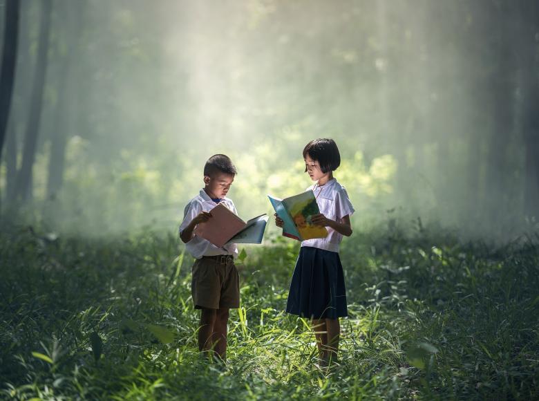 Two students in natures setting studying materials together
