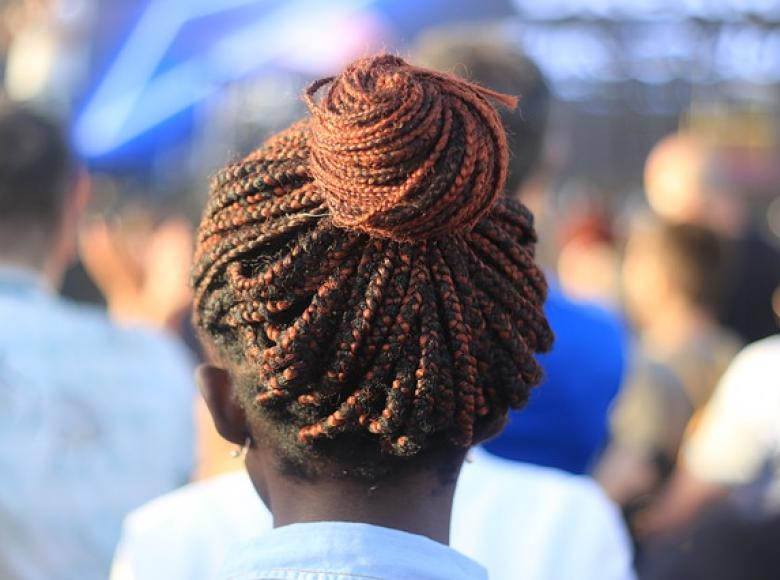 African descent woman with hair in a bun walking away from the camera