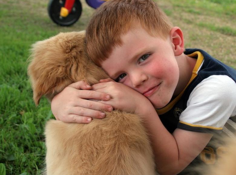 Young boy hugging his dog