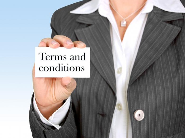 A business person holding a card that states "terms and conditions"