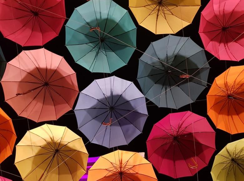 Several open colorful umbrellas from the top view